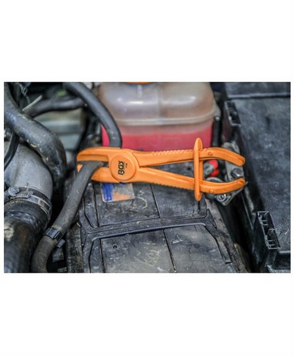 oranje slangklemtang of leidingklem in gebruik bij een auto reparatie